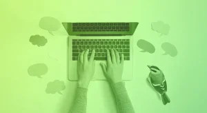 A laptop with a person's lands seen from above, typing. The laptop is surrounded by post-its in thought and speech bubble shapes, and a bird sits besides the user's hands, looking at the computer screen.